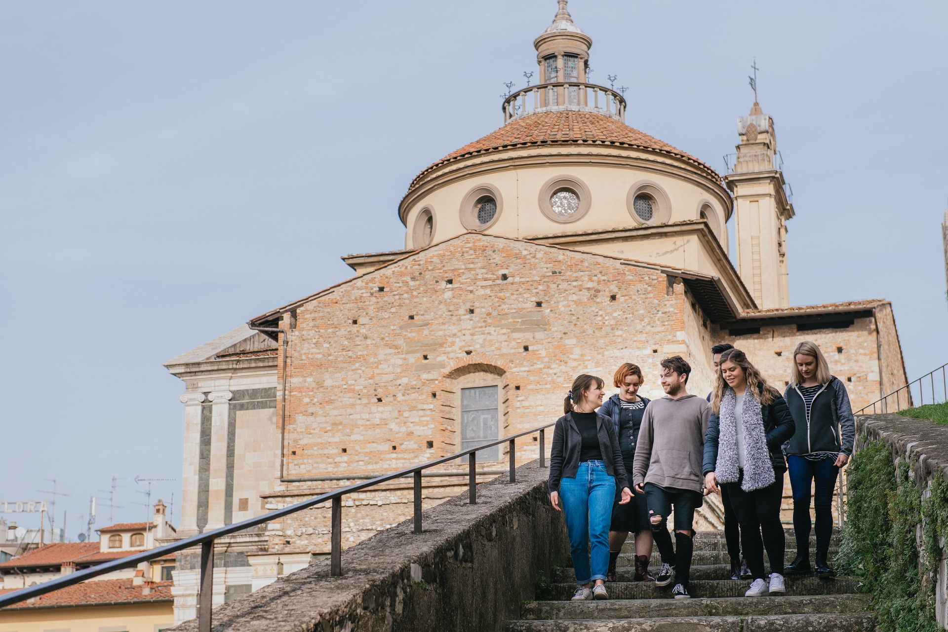 Academy participants walking down the steps of the Castello dell'Imperatore, with Santa Maria delle Carceri behind